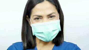 uma fêmea médico coloca em uma mascarar e sorri. video