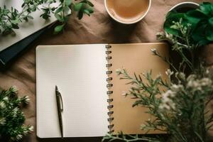 A notebook with a pen on top of it next to a cup of coffee photo