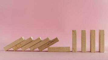 The wooden toys falling down on pink background photo
