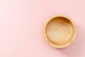 Wooden bowl on pink background photo