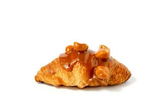 Croissant with caramel sauce and macadamia nut on white background photo
