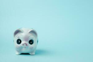 Saving piggy bank on blue background photo