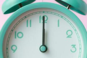 An enlarged image of a bell alarm clock with the hands pointing to noon photo