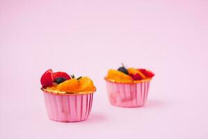 Mini paper cup of fruit or orange sponge cake photo