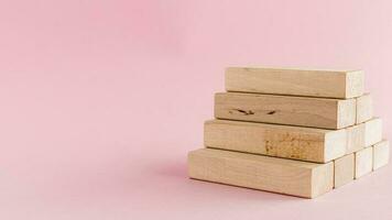 Wooden toy staircase on pink background photo