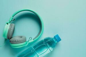 Fresh drinking water with headphones on blue background photo