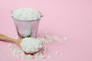 Sea salt in a wooden spoon and full of a tin bucket photo