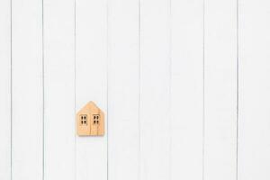 Flat lay of the wooden house model on white table background photo