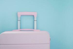 Pink luggage on blue background photo