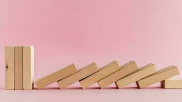 The wooden toys arranged in a horizontal row but the next others falling down photo