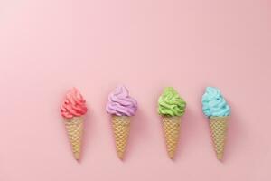 Various of colourful meringue ice cream cone on pink background photo