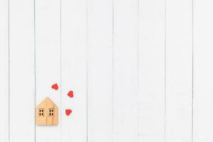 Flat lay of the wooden house model with red heart photo