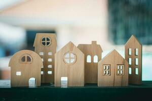 Wooden house model against blurred outdoor background photo