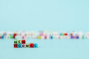 NEW NORMAL word with letter beads on blue background photo