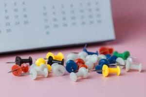 Push pins with blurred calendar photo
