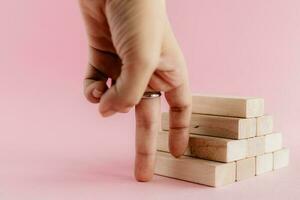 Fingers moving step up the wooden toy staircase photo