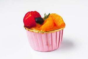 Mini paper cup of fruit or orange sponge cake photo