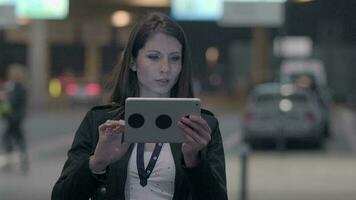 ung attraktiv självsäker kvinna använder sig av mobil läsplatta skärm medan reser på företag resa video