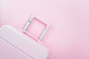 Pinky luggage on pink pastel colored background photo