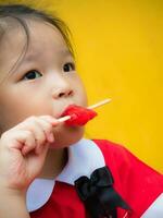 niñas en rojo estudiante vestida comiendo una paleta roja foto