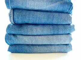 Pile of blue jeans, fabric texture photo