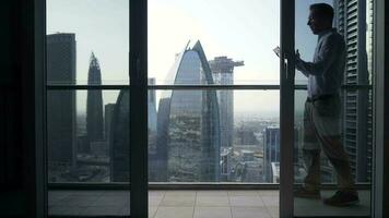 a man is using his tablet at night inside modern city apartment with skyline view video