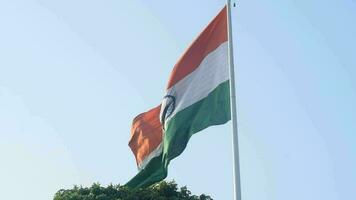 India flag flying high at Connaught Place with pride in blue sky, India flag fluttering, Indian Flag on Independence Day and Republic Day of India, tilt up shot, Waving Indian flag, Har Ghar Tiranga video