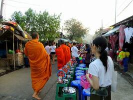 The Pindapata of Thai monks at Saphan Mon Bridge, the Buddhist monk's alms-food gathering, Alms Giving to Monks known as 'Tak Bart' in Thai photo