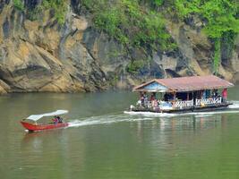 Floating house dragging by boat, Kanchanaburi, Thailand photo