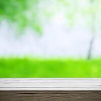 Empty wooden table with blurred green garden background. For product display. photo
