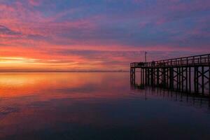 muelle a puesta de sol en móvil bahía foto