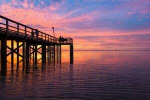 muelle a puesta de sol en móvil bahía foto