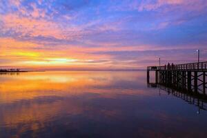 muelle a puesta de sol en móvil bahía foto