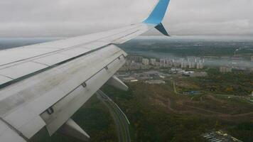 pasajero avión que se acerca a aterrizaje mediante el nubes ala, solapas, ver desde el porta. video