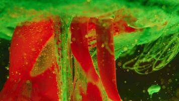 green and red ink reacting in water creating abstract background video