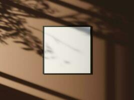 Minimal picture poster frame mockup on the wall with window shadow and leaves photo