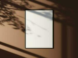 Minimal picture poster frame mockup on the wall with window shadow and leaves photo