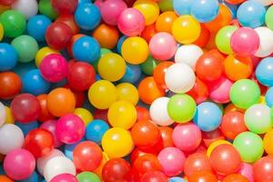 A vibrant background array of balloons illuminates the image with a carnival-like atmosphere varied in color, float above the pool photo