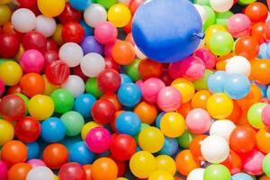 A vibrant background array of balloons illuminates the image with a carnival-like atmosphere varied in color, float above the pool photo