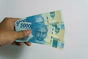 mujer mano participación dinero Indonesia, aislado en blanco antecedentes foto