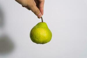 Hand of woman holding delicious ripe pear on white background photo