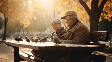 abuelos día. un mayor Pareja en el parque en un banco alimentar palomas ai generado. foto