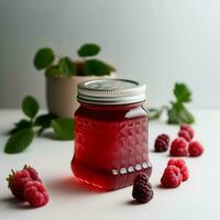 Raspberry jam in glass jar on white table photo