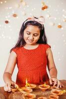 a young girl in a red dress lighting candles photo