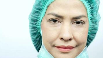 Close-up, smiling doctor looking at camera wearing face mask properly video