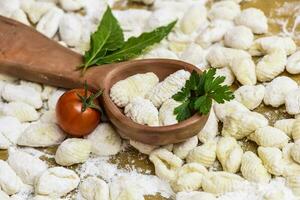 Homemade gnocchi, prepared on the table with ingredients. photo