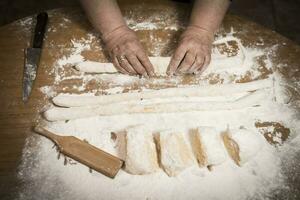 Hands kneading dough for gnocchi. photo