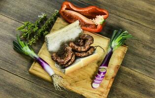 Cow bowels presented on a wooden board with ingredients, ready to grill photo