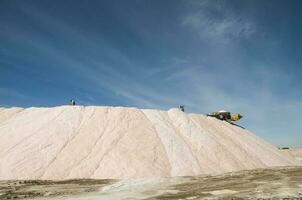 Trucks unloading raw salt bulk, Salinas Grandes de Hidalgo, La Pampa, Argentina. photo