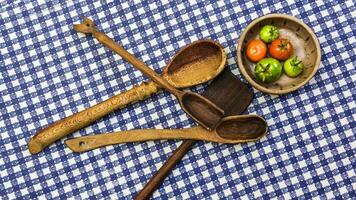Rustic wooden spoons amd tomatoes on the table. photo